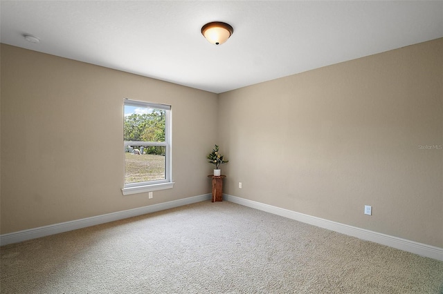 unfurnished room featuring carpet floors and baseboards