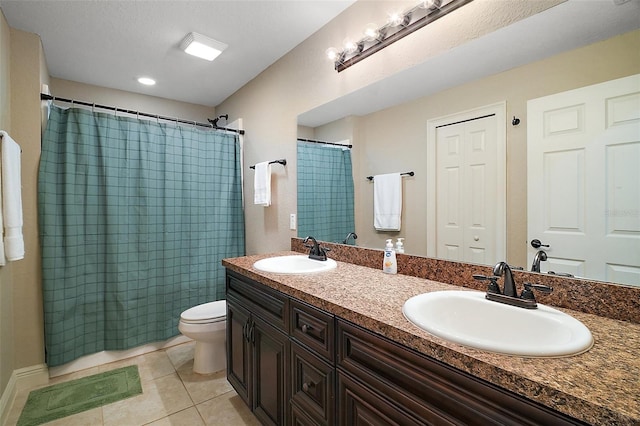 full bathroom featuring a sink, tile patterned floors, toilet, and double vanity
