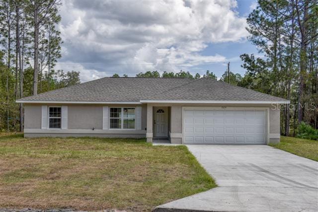 ranch-style house featuring an attached garage, stucco siding, a front yard, and concrete driveway