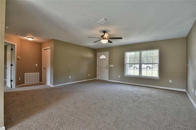 empty room with ceiling fan, visible vents, baseboards, and carpet