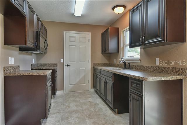 kitchen featuring black microwave and a sink