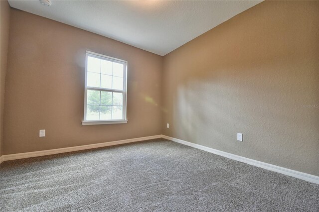 empty room featuring baseboards and carpet