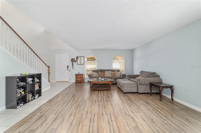 living room featuring baseboards, stairs, and wood finished floors
