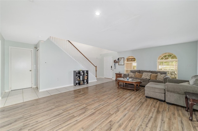 living room with baseboards, stairs, and wood finished floors