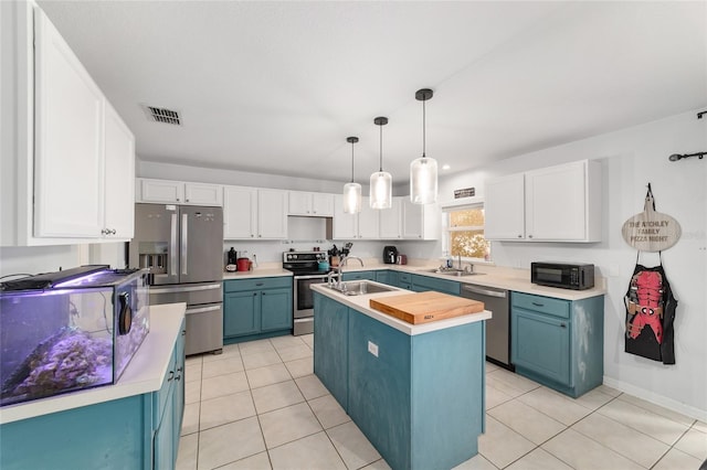 kitchen featuring blue cabinetry, appliances with stainless steel finishes, a sink, and visible vents