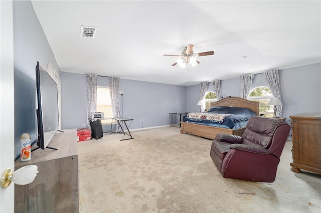 carpeted bedroom with visible vents, a ceiling fan, baseboards, and multiple windows