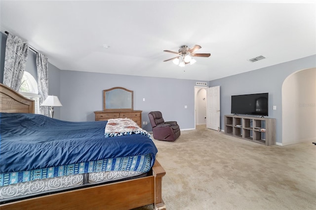bedroom with carpet floors, arched walkways, baseboards, and visible vents