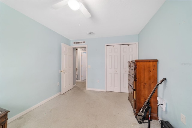 bedroom with a ceiling fan, light colored carpet, visible vents, baseboards, and a closet