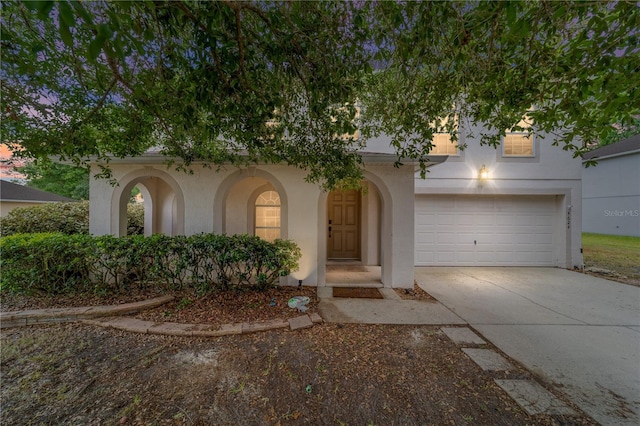 view of front facade featuring an attached garage, stucco siding, and concrete driveway