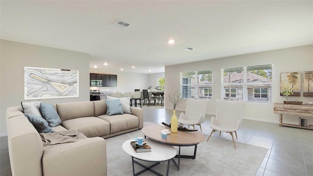 living area with recessed lighting, visible vents, a healthy amount of sunlight, and light tile patterned floors