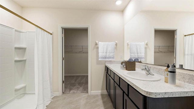 full bath with a shower with shower curtain, double vanity, tile patterned floors, and a sink