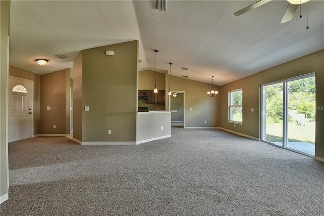 unfurnished living room with a textured ceiling, visible vents, vaulted ceiling, baseboards, and ceiling fan with notable chandelier
