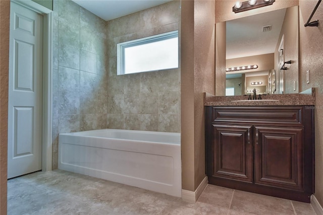 full bathroom featuring baseboards, visible vents, a bath, and vanity