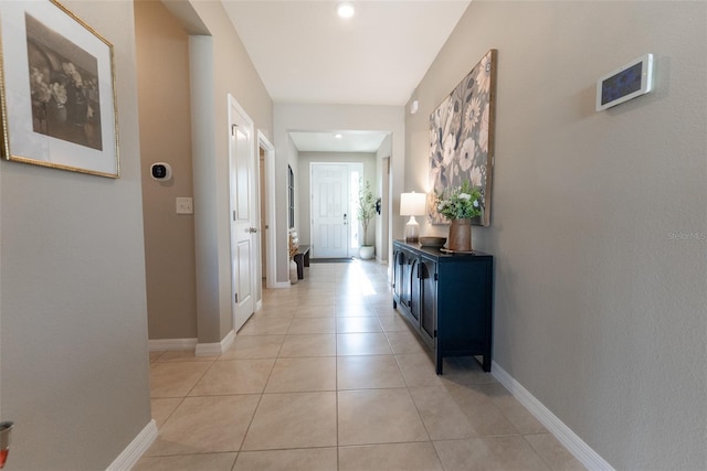 hallway with baseboards and light tile patterned floors