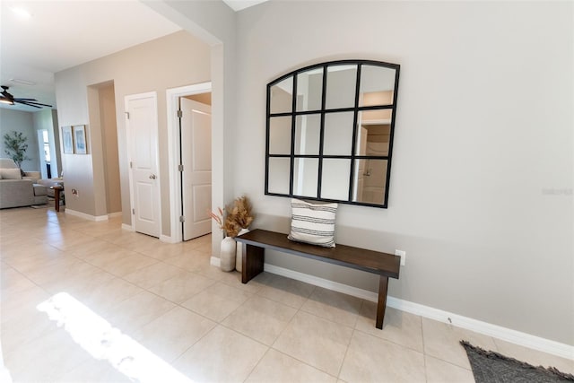 corridor with baseboards and light tile patterned floors