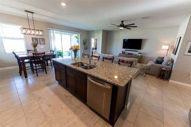 kitchen featuring visible vents, decorative light fixtures, dishwasher, a sink, and light tile patterned floors