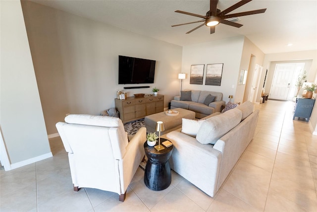 living area featuring light tile patterned floors, baseboards, and a ceiling fan