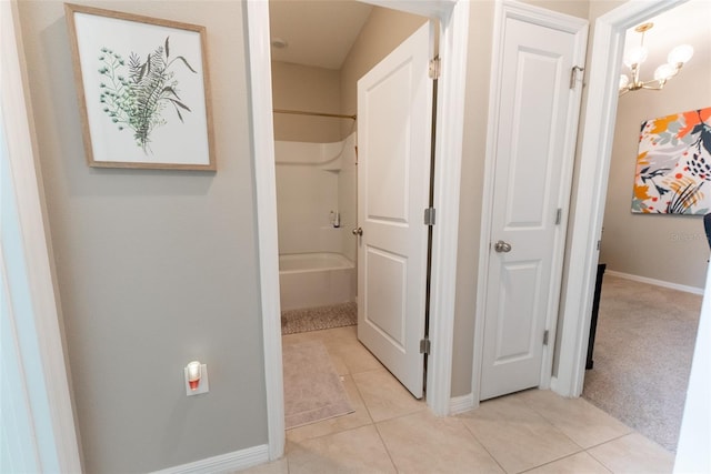 full bathroom featuring tile patterned floors, a chandelier, washtub / shower combination, and baseboards