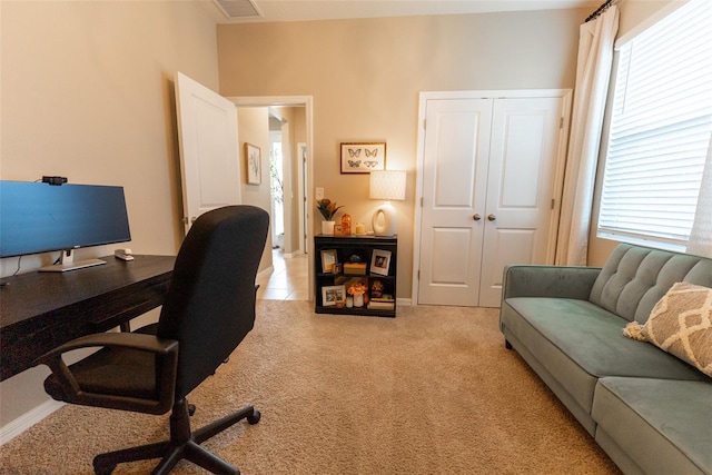 office area featuring visible vents and light carpet