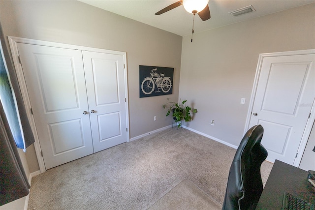 unfurnished office with carpet flooring, a ceiling fan, baseboards, and visible vents