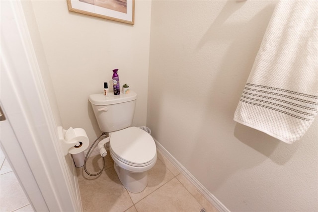 bathroom with tile patterned floors, baseboards, and toilet