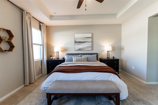bedroom featuring carpet flooring, baseboards, and a raised ceiling