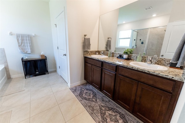 full bath with a sink, a stall shower, double vanity, and visible vents