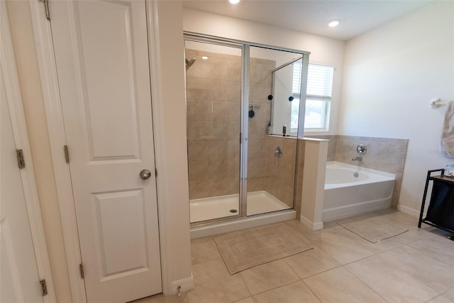 full bath featuring a garden tub, baseboards, tile patterned floors, and a shower stall