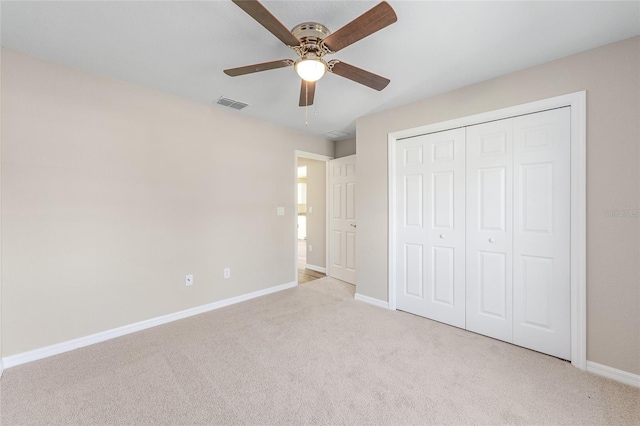 unfurnished bedroom featuring light colored carpet, baseboards, a closet, and ceiling fan
