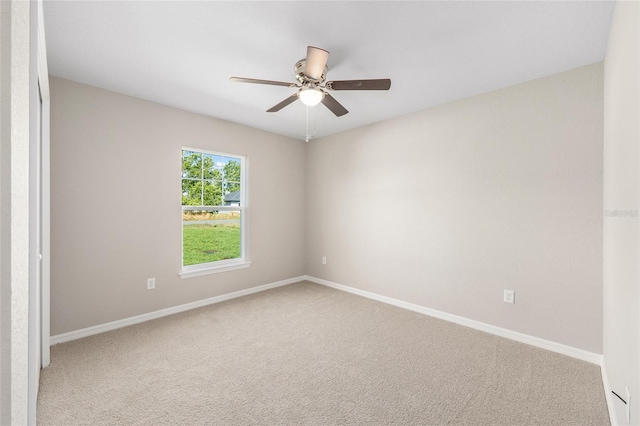 carpeted empty room featuring ceiling fan and baseboards