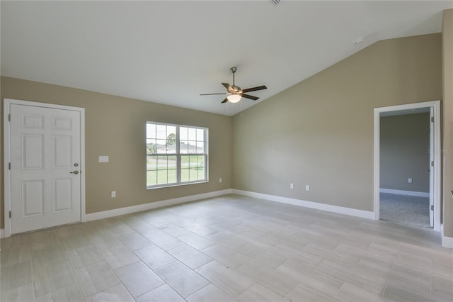 empty room featuring baseboards, a ceiling fan, and vaulted ceiling