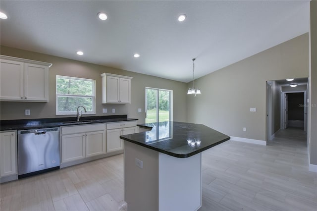 kitchen featuring a center island, dishwasher, a sink, lofted ceiling, and white cabinetry