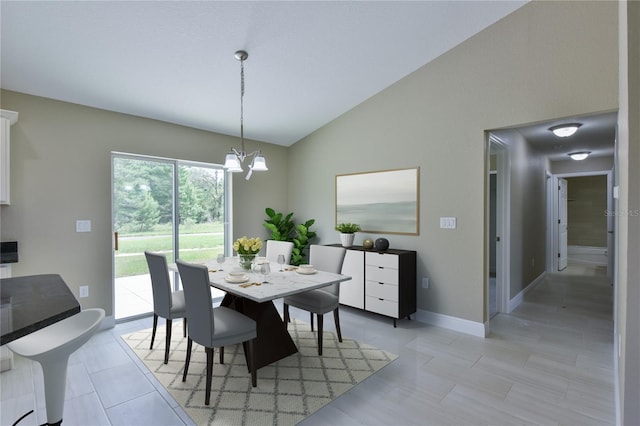 dining area featuring an inviting chandelier, baseboards, and vaulted ceiling