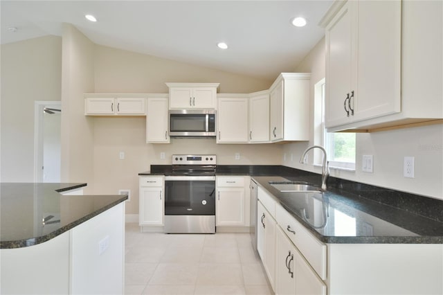 kitchen featuring a sink, vaulted ceiling, stainless steel appliances, and white cabinetry