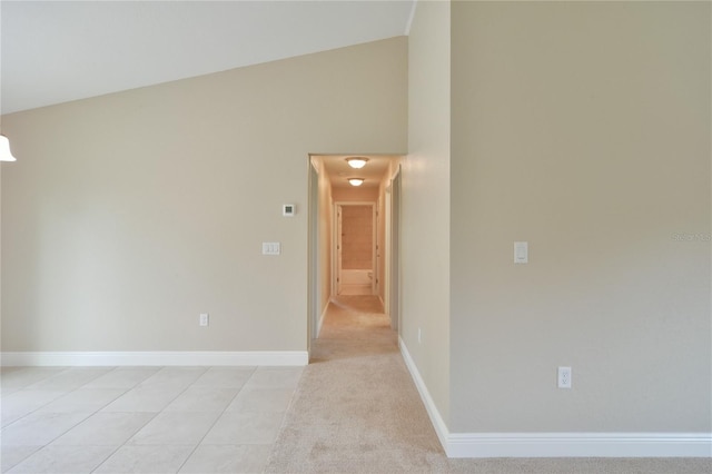 unfurnished room featuring baseboards and high vaulted ceiling