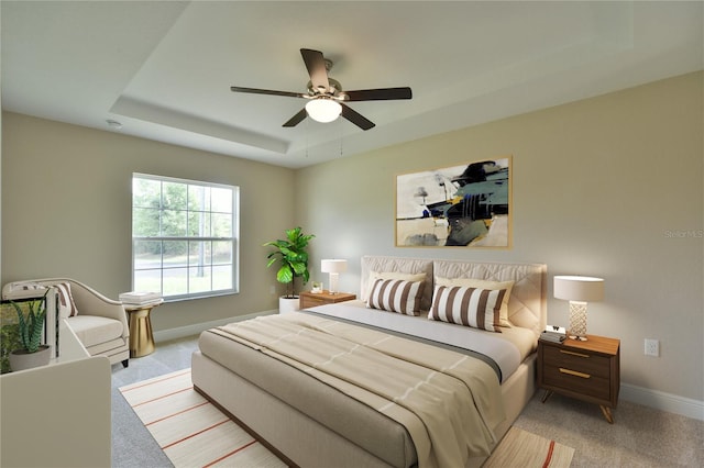 carpeted bedroom featuring baseboards, a ceiling fan, and a tray ceiling