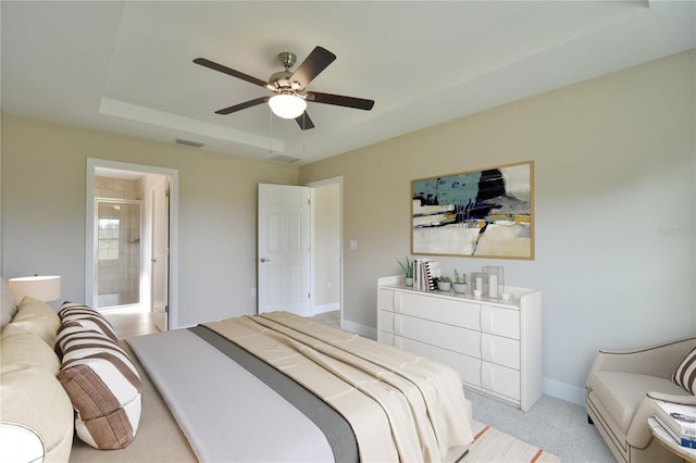 bedroom with visible vents, baseboards, ensuite bathroom, light colored carpet, and a ceiling fan
