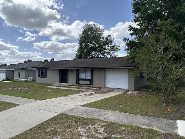 single story home featuring roof with shingles, an attached garage, driveway, and a front yard