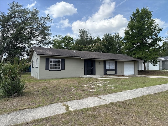 view of front of home with driveway, a front yard, roof with shingles, an attached garage, and concrete block siding