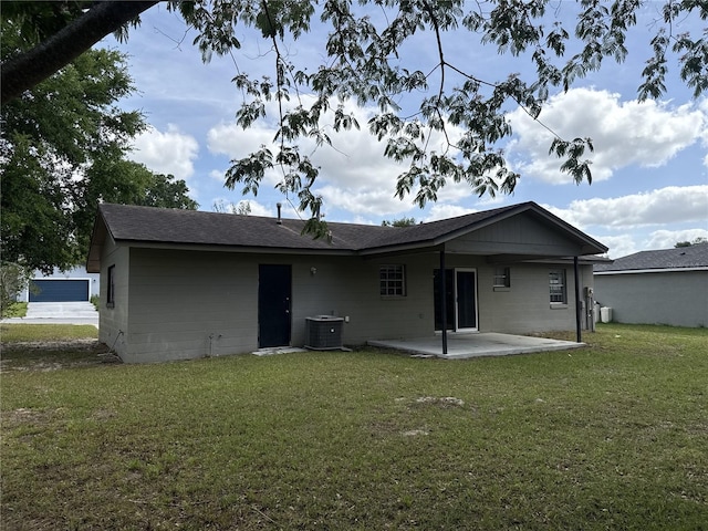 rear view of house with a patio, a lawn, roof with shingles, and cooling unit