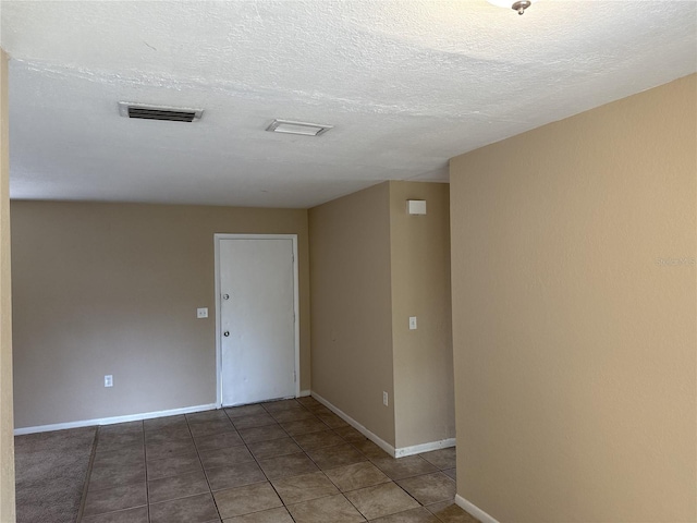 empty room with visible vents, baseboards, and tile patterned floors