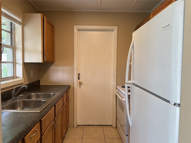 kitchen with a sink, dark countertops, brown cabinets, and white appliances