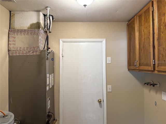 laundry area featuring cabinet space and heating unit