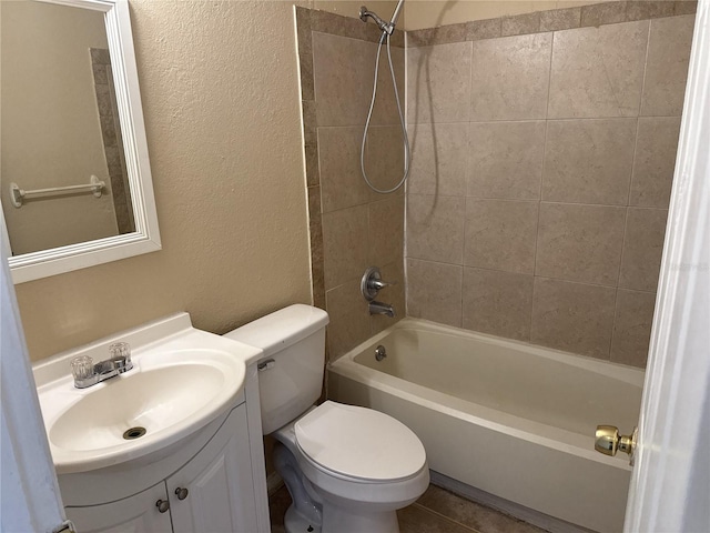 bathroom with vanity, a textured wall, washtub / shower combination, and toilet