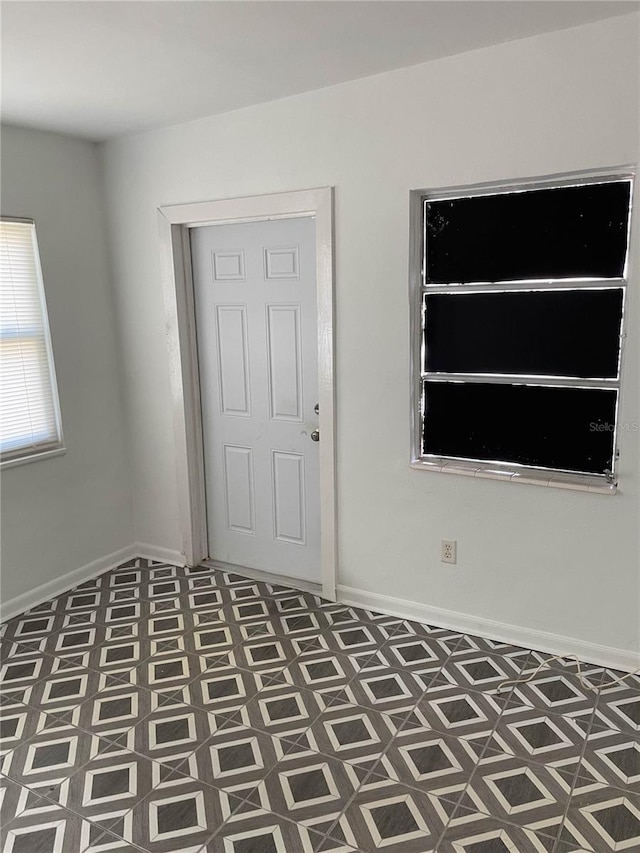 unfurnished room featuring tile patterned floors and baseboards