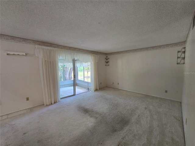 carpeted empty room featuring baseboards and a textured ceiling