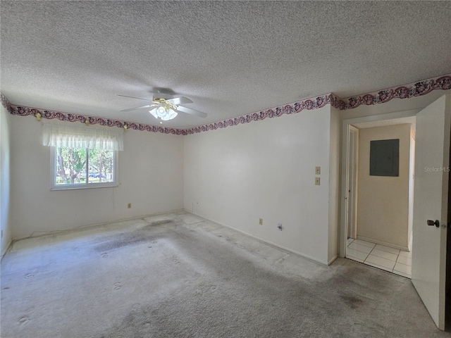 unfurnished room with carpet floors, a ceiling fan, a textured ceiling, and electric panel