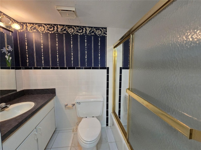 bathroom featuring visible vents, tile walls, vanity, tile patterned floors, and combined bath / shower with glass door