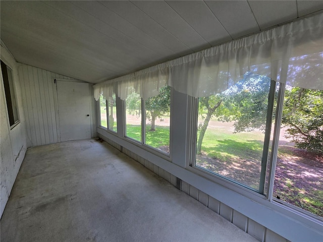 unfurnished sunroom with concrete floors and lofted ceiling