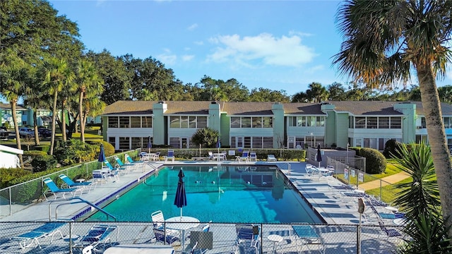 community pool with fence and a patio